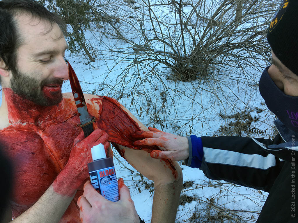 Actor Mike is getting some extra blood applied underneath his skin before a take.